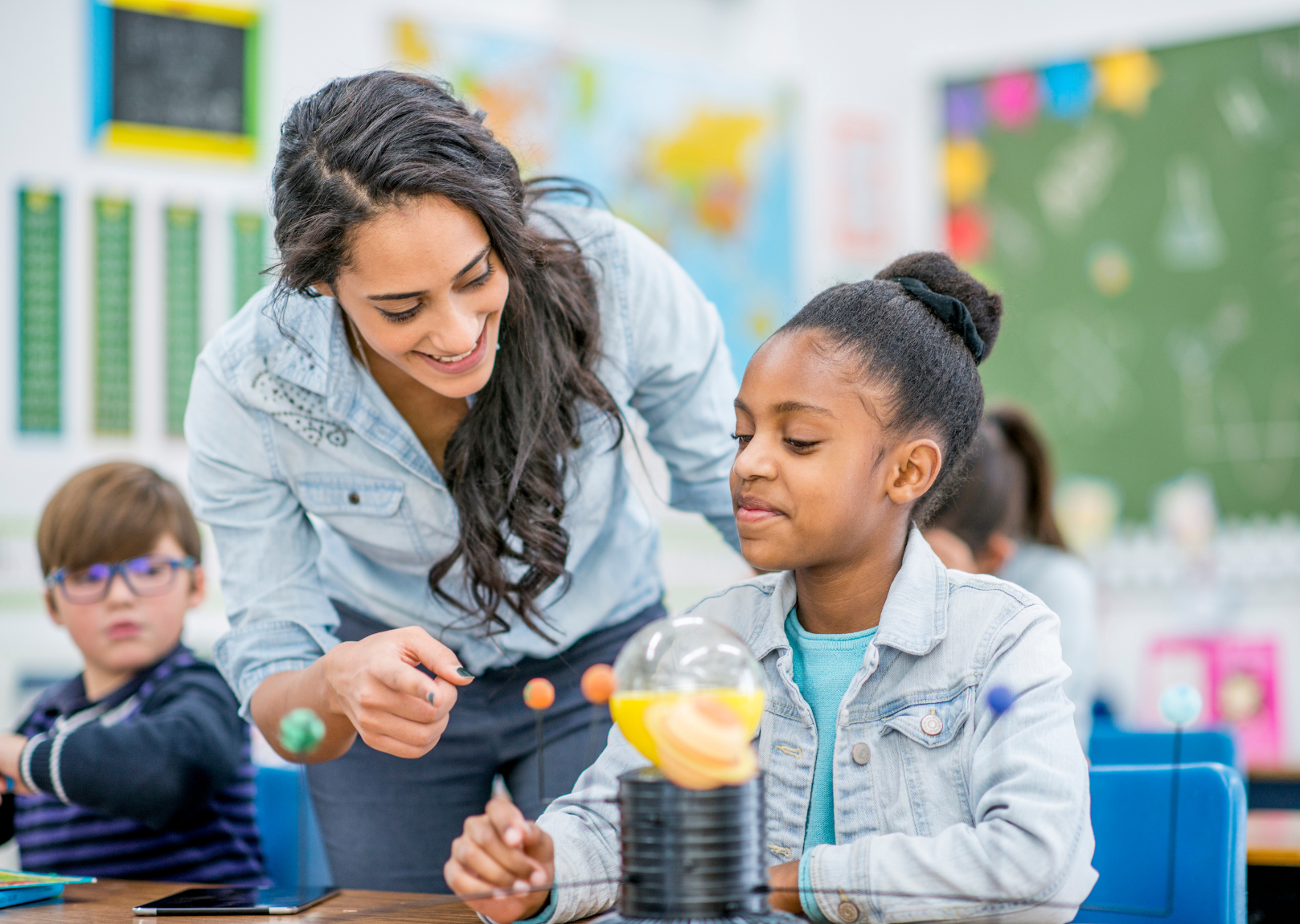 A teacher assists a student in applying math skills to a science project.